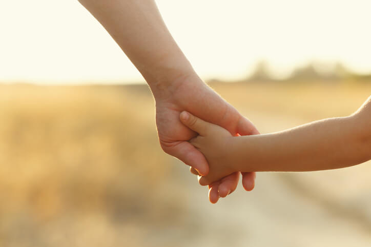 Parent holding child's hand