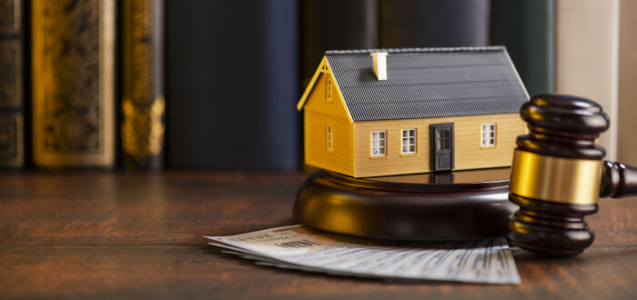 A small house with a gavel symbolizing real estate litigation
